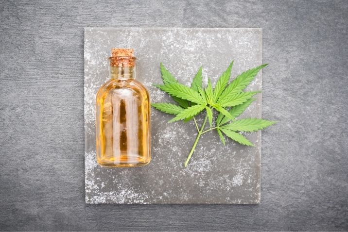 a bottle with cbd tincture and hemp leaf