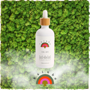 Rainbo 11:11 Tincture bottle placed on a moss green background, showcasing its sleek design and minimalist label featuring a blend of medicinal mushrooms for wellness and vitality.