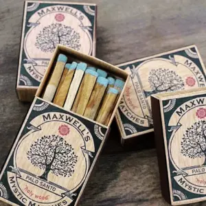 Open and closed boxes of Maxwell's Palo Santo mystic matches with blue-tipped matchsticks inside.