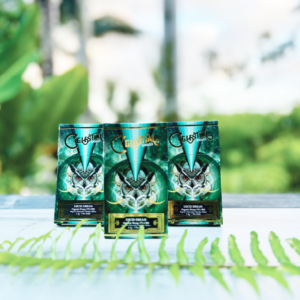 Three Celestial Smokes “Lucid Dream” product packages displayed outdoors on a wooden surface with green foliage in the background