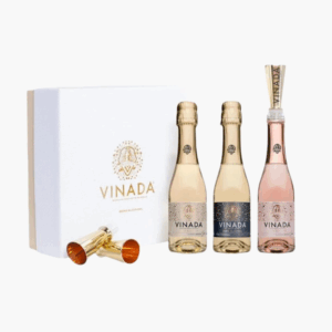 A set of three mini Vinada zero-alcohol sparkling wine bottles with a white gift box and two gold-colored shot glasses