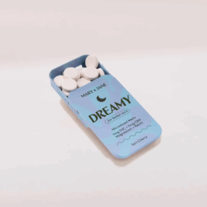 A blue tin labeled 'Dreamy' containing white round microdosed THC and CBN melts for better sleep