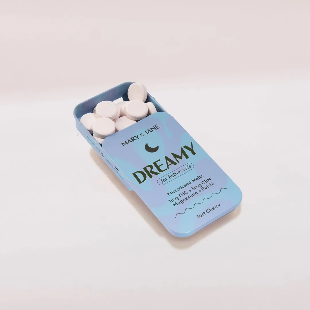 A blue tin labeled 'Dreamy' containing white round microdosed THC and CBN melts for better sleep